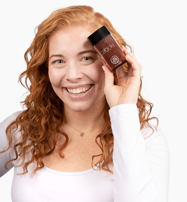 Image of a woman with reddish-brown hair holding a Caboki 30g